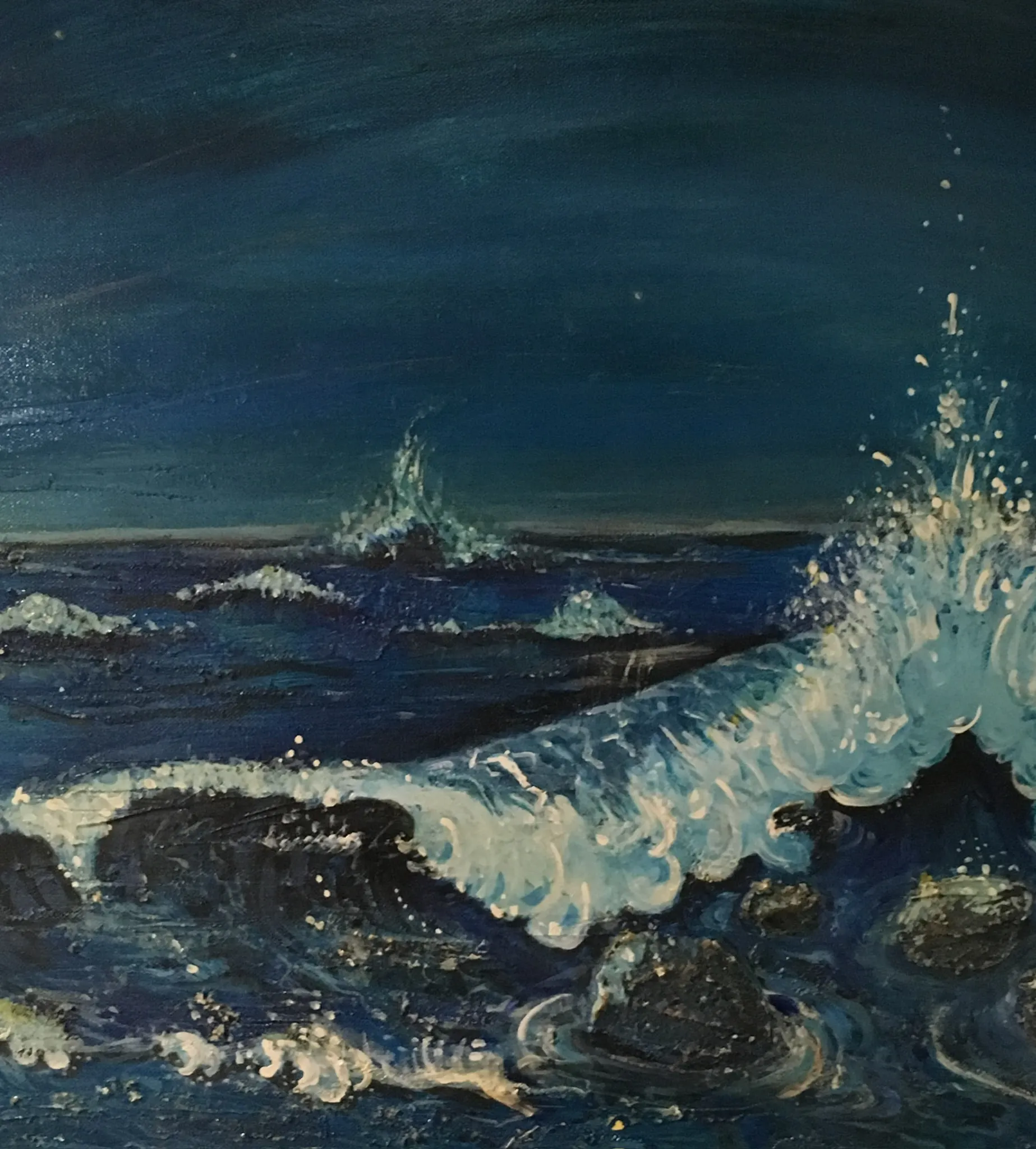 A dark night sea in deep blues and near-black, a white wave breaking over foreground rocks with spray leaping to the right under a midnight sky faintly touched with stars