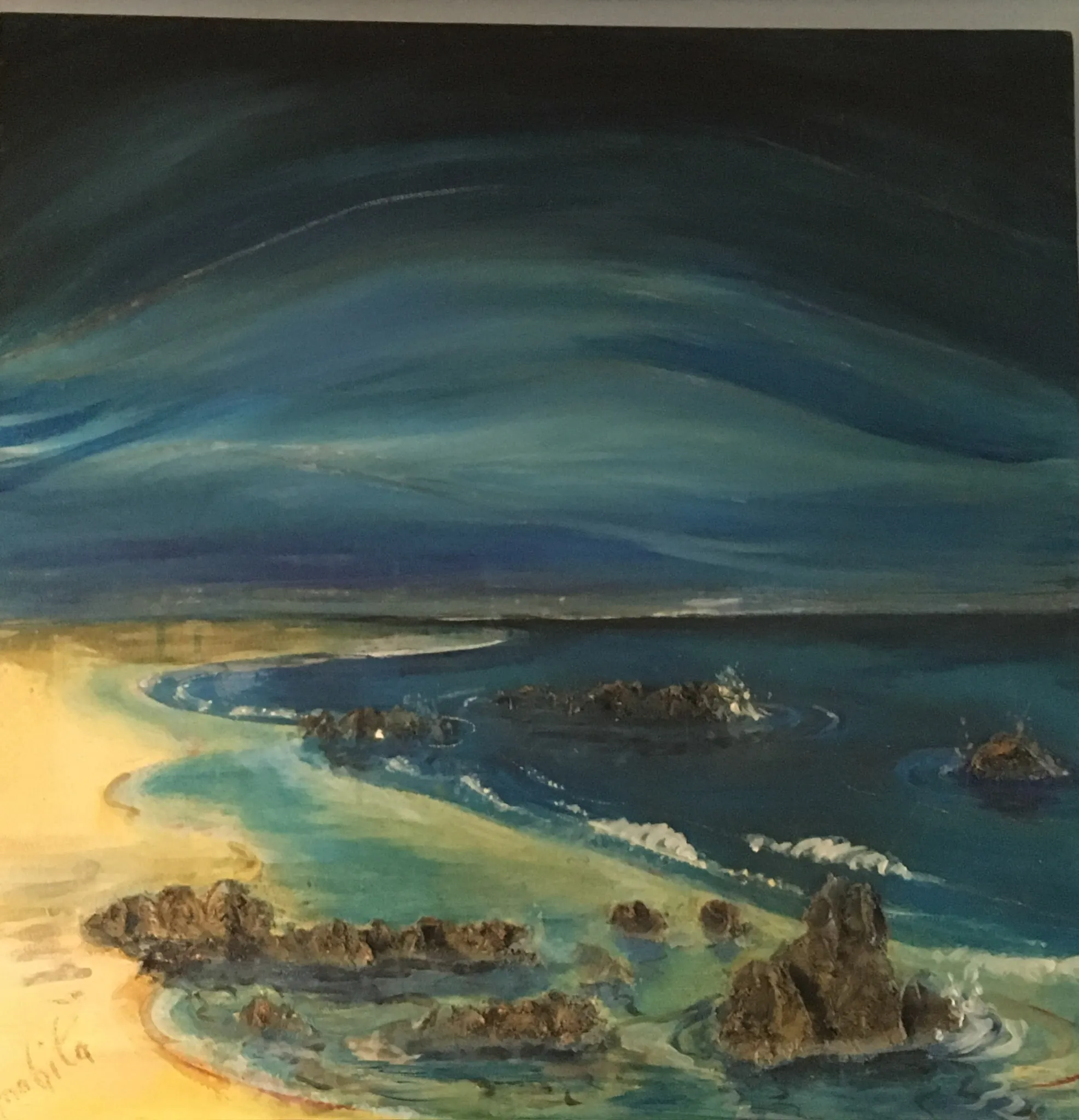 Aerial view of a curving yellow beach meeting a deep blue bay with dark rocky outcrops and green shallows, a swept dark blue and green sky above the low horizon